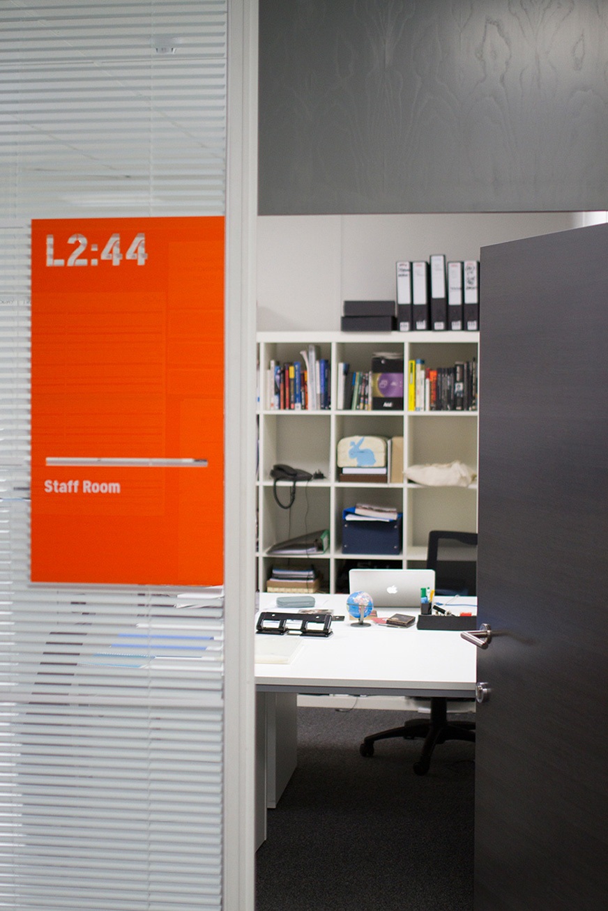 Orange acrylic sign with numerical room identifier