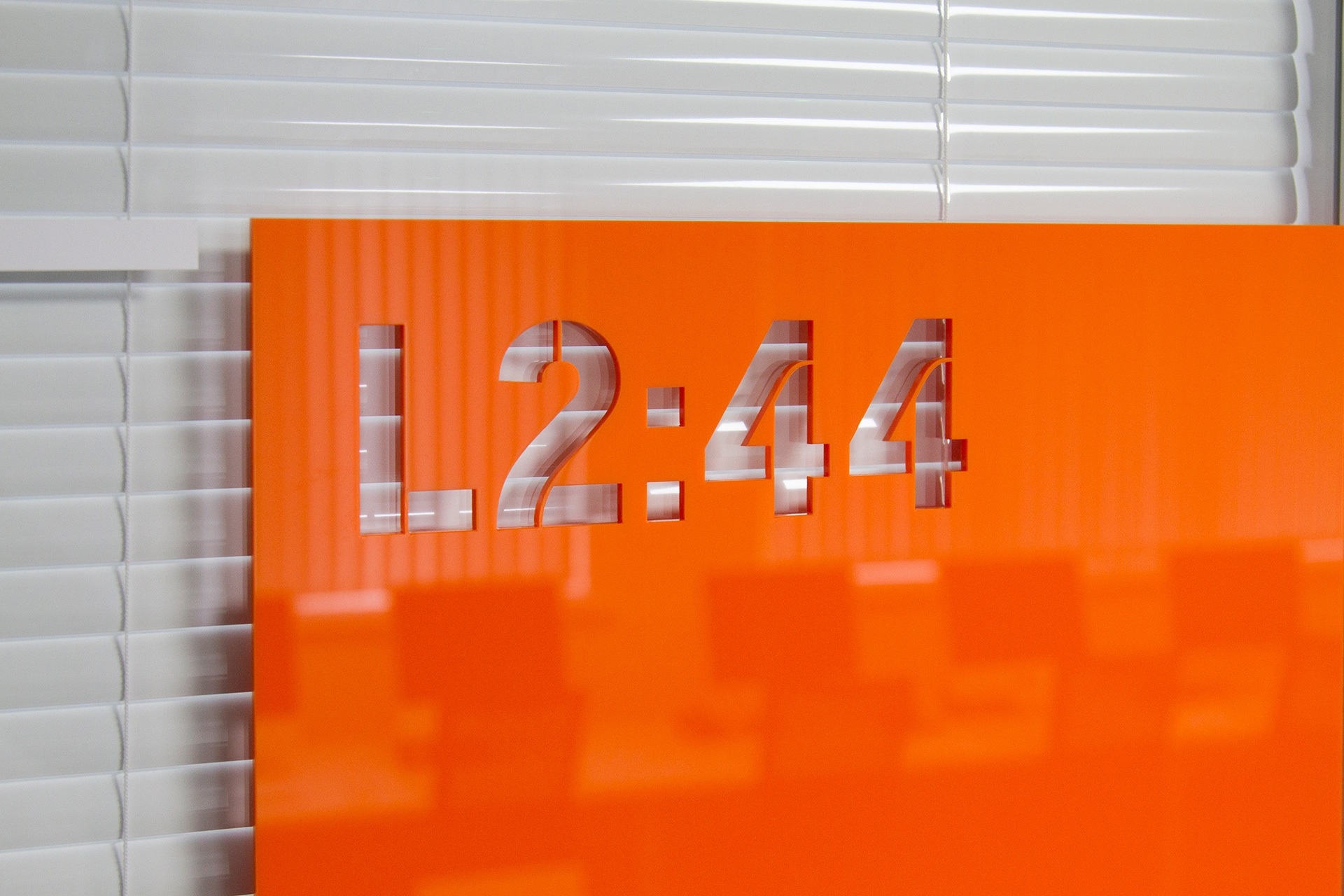 Laser cut room numbers in stencil typeface on orange acrylic