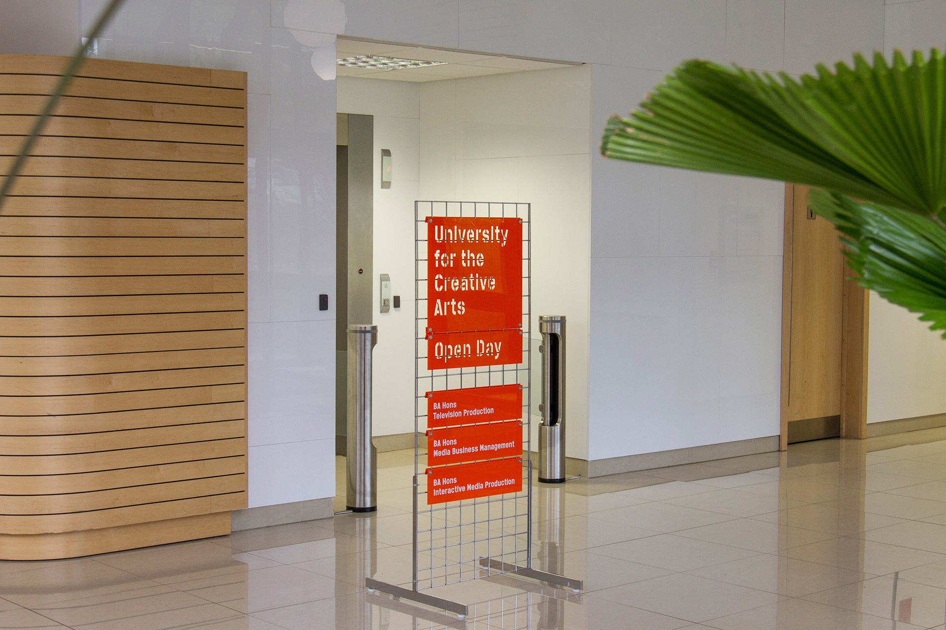Freestanding gridwall sign with orange laser cut acrylic attached