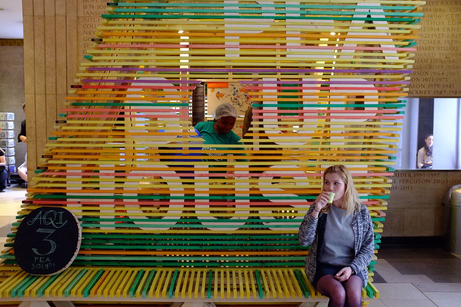 Visitor sitting infront of the installation whilst drinking pea soup.